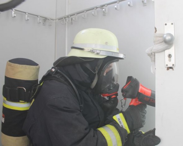 Wärmebildkamera Würfelblick Ein Feuerwehrmann kontrolliert einen Raum durch den Türspalt mit dem Würfelblick.